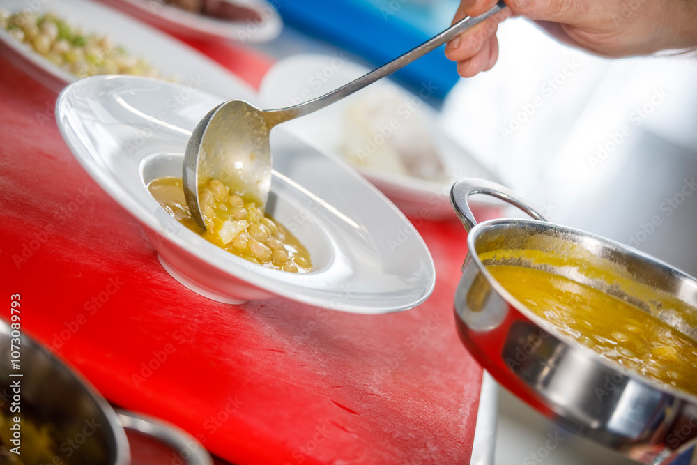 Chef is serving some white beans in a plate Chef is serving some white beans in a plate