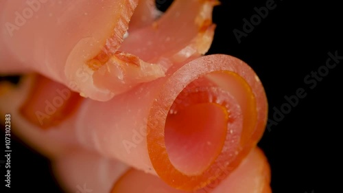 Dried meat beef jerky slice on fork on black background.