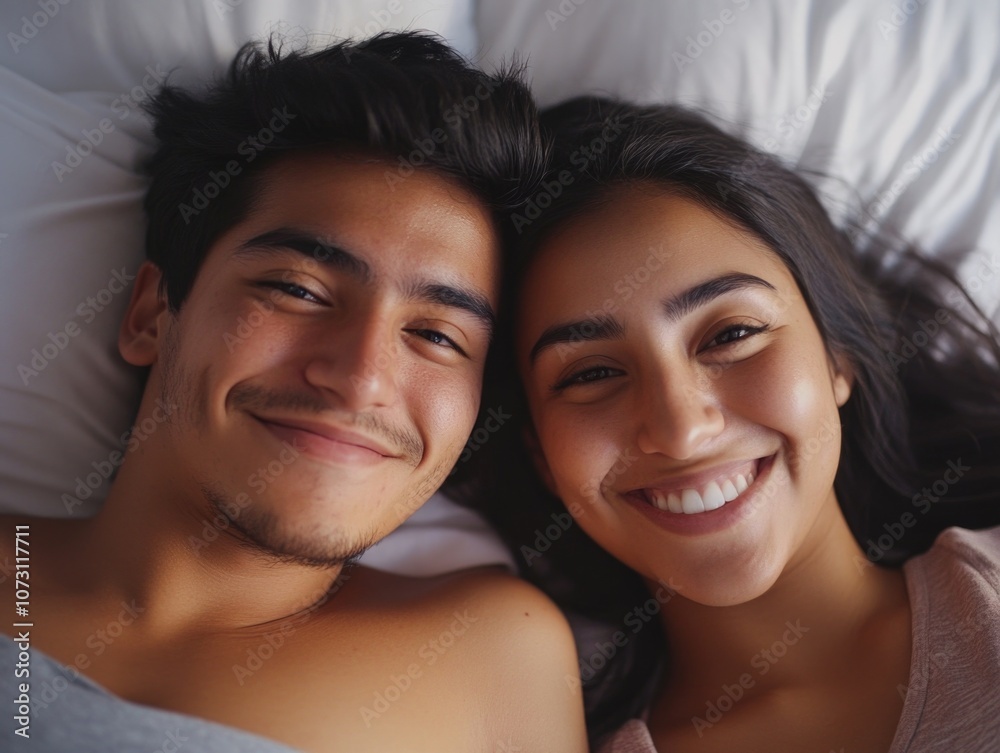 A young man and woman enjoying each other's company in a relaxed bedroom setting. A young man and woman enjoying each other's company in a relaxed bedroom setting.