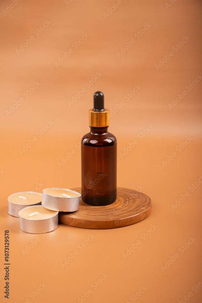 Amber Dropper Bottles with Tealight Candles on Warm Background for Spa and Aromatherapy