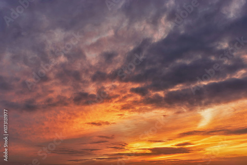 Sunset sky with bright orange and purple hues in a tranquil landscape at dusk