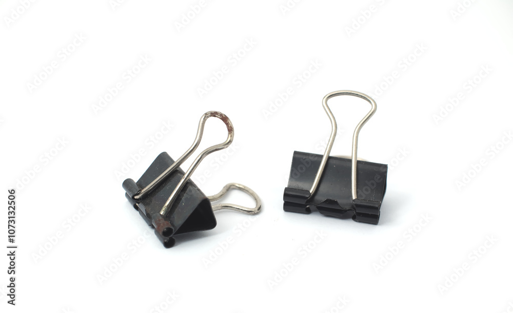 Pair of Small Binder Clip. Two small black binder clips placed next to each other on a white background