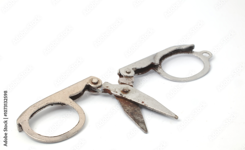 Partially opened scissors showing a view of the blades and handles on a white background. Partially opened scissors showing a view of the blades and handles on a white background.