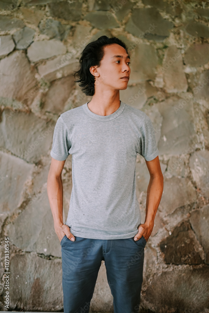 Southeast Asian man standing and looking to the side with a calm expression Southeast Asian man standing and looking to the side with a calm expression