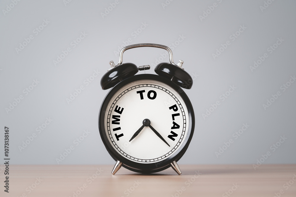 Black alarm clock with time to plan on table for business planing concept. Black alarm clock with time to plan on table for business planing concept.