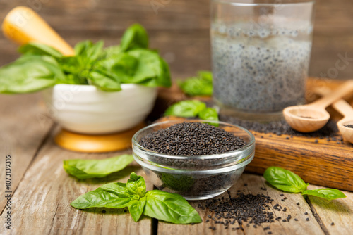 Basil seeds on textured wooden background. Close-up. Superfood. Ocimum basilicum. Organic basil seeds. selasih. Space for text. Copy space. photo