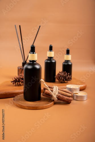 Matte Black Dropper Bottles with Reed Diffuser, Pinecones, and Tealight Candles in Spa Decor