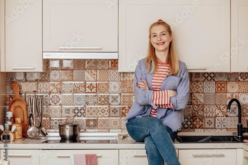 Modern Kitchen Lifestyle - Showcasing a warm, contemporary kitchen space with a cheerful individual embodying comfort and style