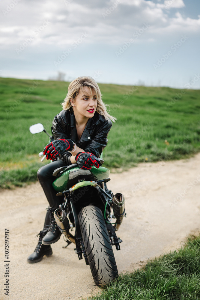 Obraz premium Woman in Leather Outfit Sitting on Motorcycle. Confident woman in leather pants and jacket sitting on a motorcycle. Ideal for themes of adventure, fashion, or biker lifestyle. Captures a bold.