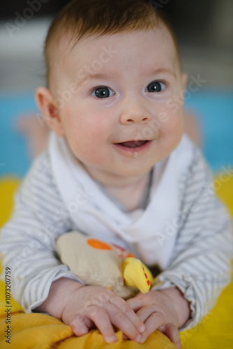 Portrait of a newborn baby. He looks at the camera and smiles. 3 months