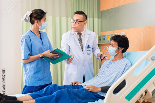 Asian doctor, nurse, and happy male patient in hospital bed showing thumbs up, indicating positive recovery and satisfaction services. Medical professionals, hospital teamwork, and medical healthcare