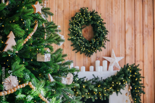 Decorative Christmas tree and festive wreath in cozy wooden interior