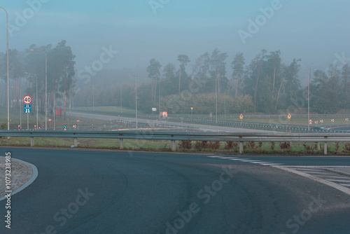 Obraz na płótnie Węzeł drogowy przy autostradzie. Widać zjazdy i rozjazdy. Nad węzłem drogowy jak i nad pobliskim lasem unosi się mgła. w salonie