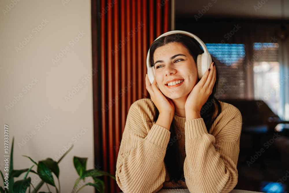 Young caucasian woman enjoying music on wireless headphones at home Young caucasian woman enjoying music on wireless headphones at home