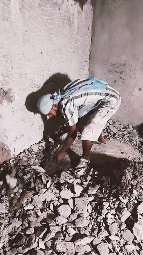This diligent worker is seen here using a shovel to clear away damaged plaster and preparing for the next phase of the project.