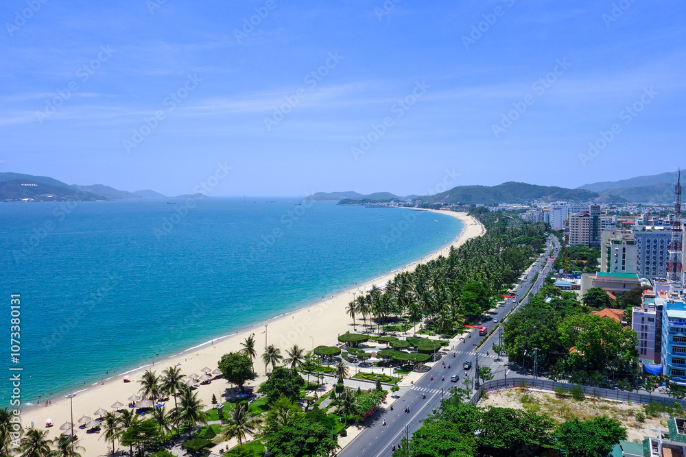 Fototapeta premium a beach with a view of a city and a blue sky