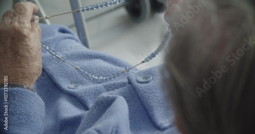 Elderly Woman Praying the Rosary. Close-up of an elderly woman holding a rosary, symbolizing faith, spirituality, and devotion. This image captures a moment of introspective, faith and resilience.