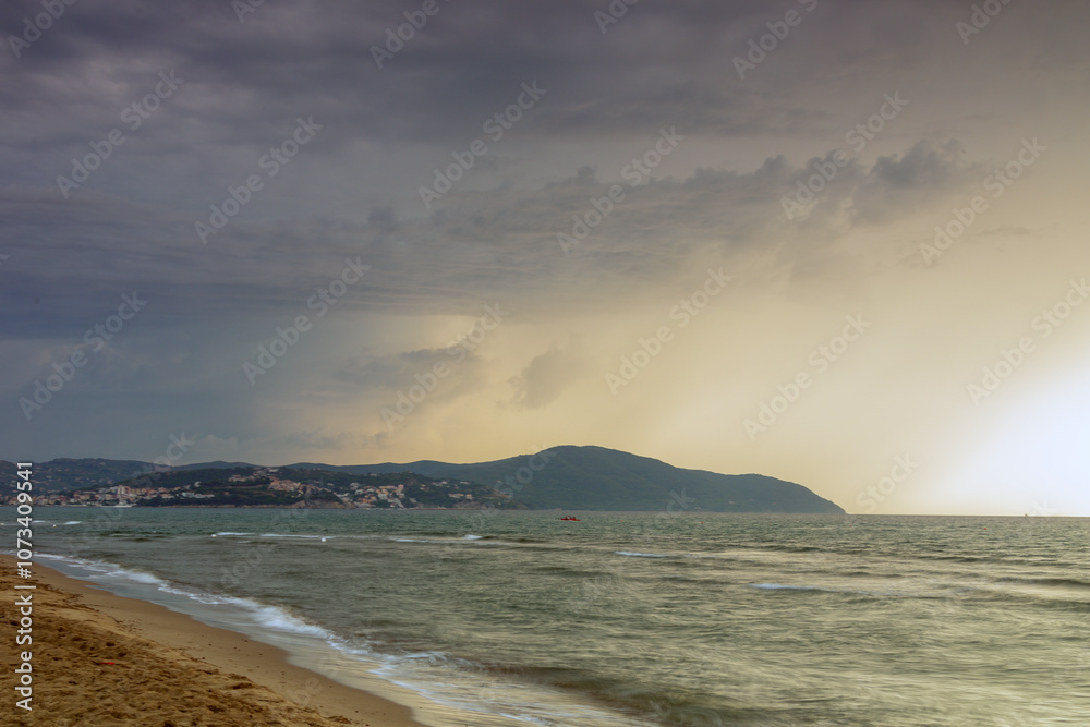 Mare in tempesta. Tramonto con nuvole e una luce di colori. Acqua vento e sole. Paesaggio marino