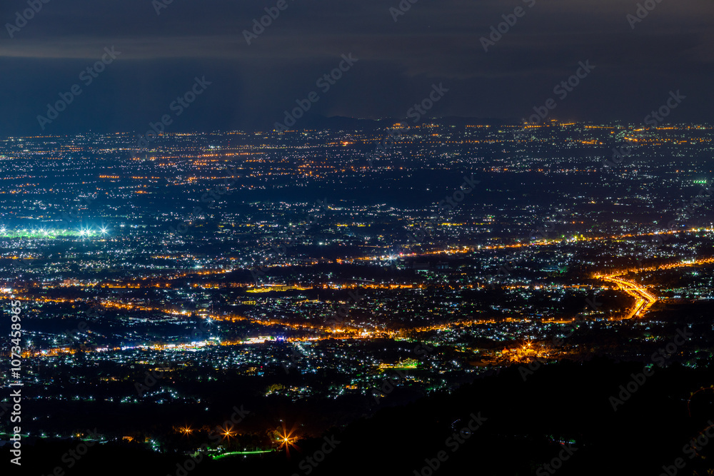 High angle view background from the mountain, showing the lights of apartment buildings, houses, car lights and street lights, the advancement of technology and electricity lighting at night. High angle view background from the mountain, showing the lights of apartment buildings, houses, car lights and street lights, the advancement of technology and electricity lighting at night.