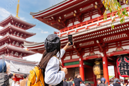 Photography Young female tourist taking a photo of sensoji temple at Asakusa district in Tok