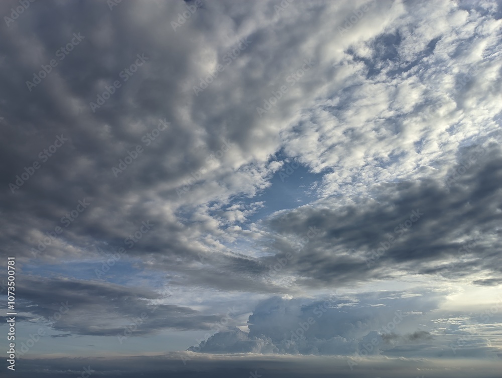 Dramatic Cloudscape with a Glimpse of Blue Sky. A captivating image of a dynamic sky filled with varying shades of gray and white clouds. Dramatic Cloudscape with a Glimpse of Blue Sky. A captivating image of a dynamic sky filled with varying shades of gray and white clouds.