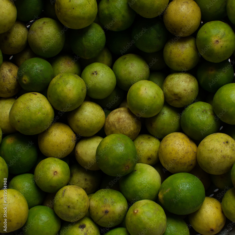 Overhead view of green limes on a white marble countertop, top view of organic limes on a white background Overhead view of green limes on a white marble countertop, top view of organic limes on a white background