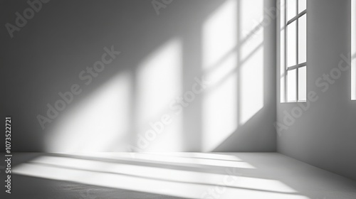 Sunlight streams through a window in an otherwise empty room, casting long shadows on the white walls and floor.