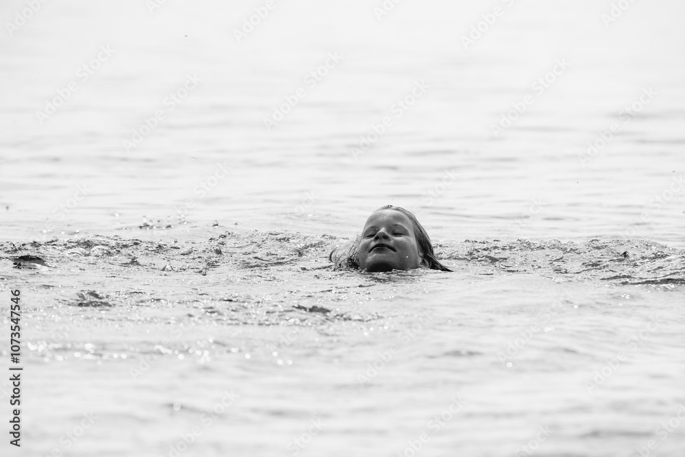 Fototapeta premium Beautiful girl playing on the pond in summer. Black and white photo.