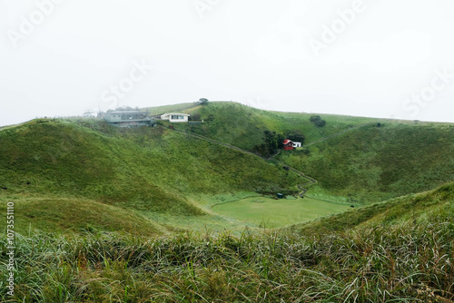 mountain view in a foggy day with the green trees grass field with small houses  photo