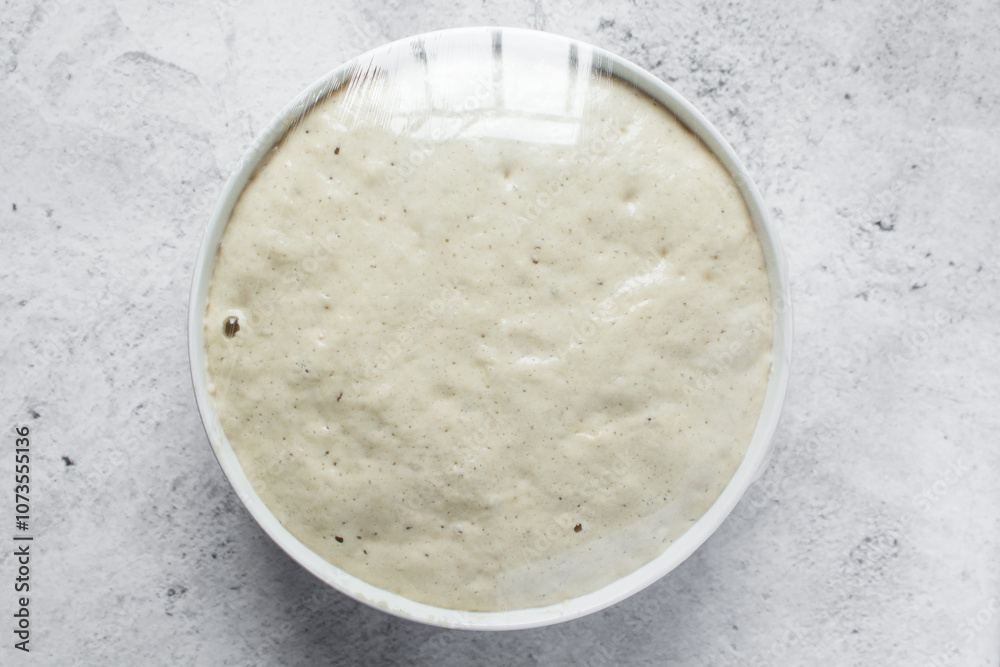 Overhead view of nigerian puff-puff dough that has proofed, puff-puff dough in a white mixing bowl, process of making puff-puff or bofrot Overhead view of nigerian puff-puff dough that has proofed, puff-puff dough in a white mixing bowl, process of making puff-puff or bofrot