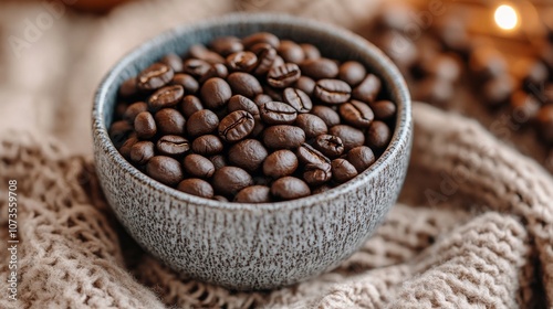 Rustic bowl of roasted coffee beans on textured fabric photo