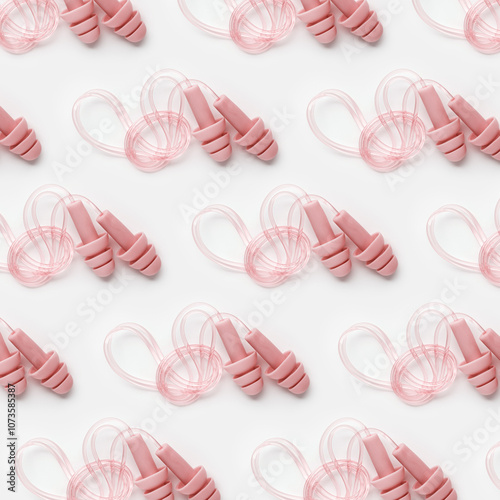 Reusable silicone pale pink color earplugs, for swim, sleep, rest as minimal trend pattern on white background. Soft, flexible ear plug on cord against noise, protect hear, top view, flatlay photo