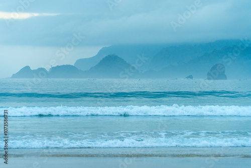 Morning mist on the white sandy beach of Red Island, Banyuwangi, Indonesia photo