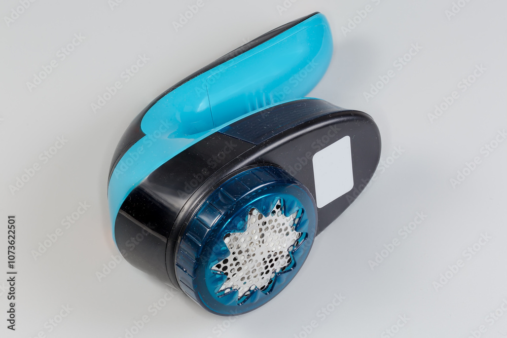 Handheld electrical fabric shaver on a gray background Handheld electrical fabric shaver on a gray background