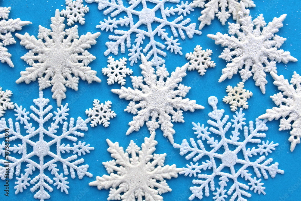 There are many white snowflake figures on a blue background.