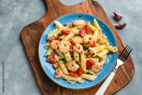 Penne pasta with shrimps and cherry tomatoes in butter and garlic sauce