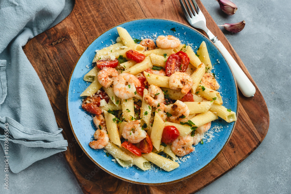 Penne pasta with shrimps and cherry tomatoes in butter and garlic sauce