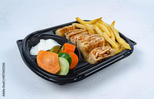 Close up of chicken shawarma meal with lettuce, tomato and onion on white background.
