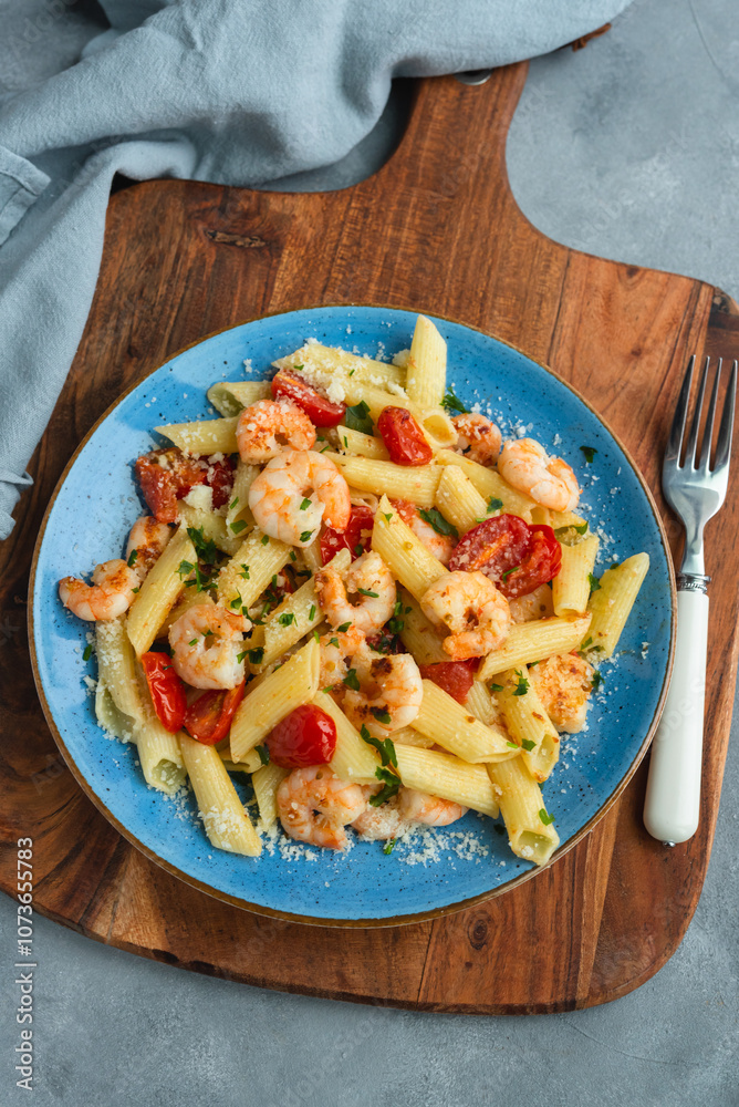 Penne pasta with shrimps and cherry tomatoes in butter and garlic sauce