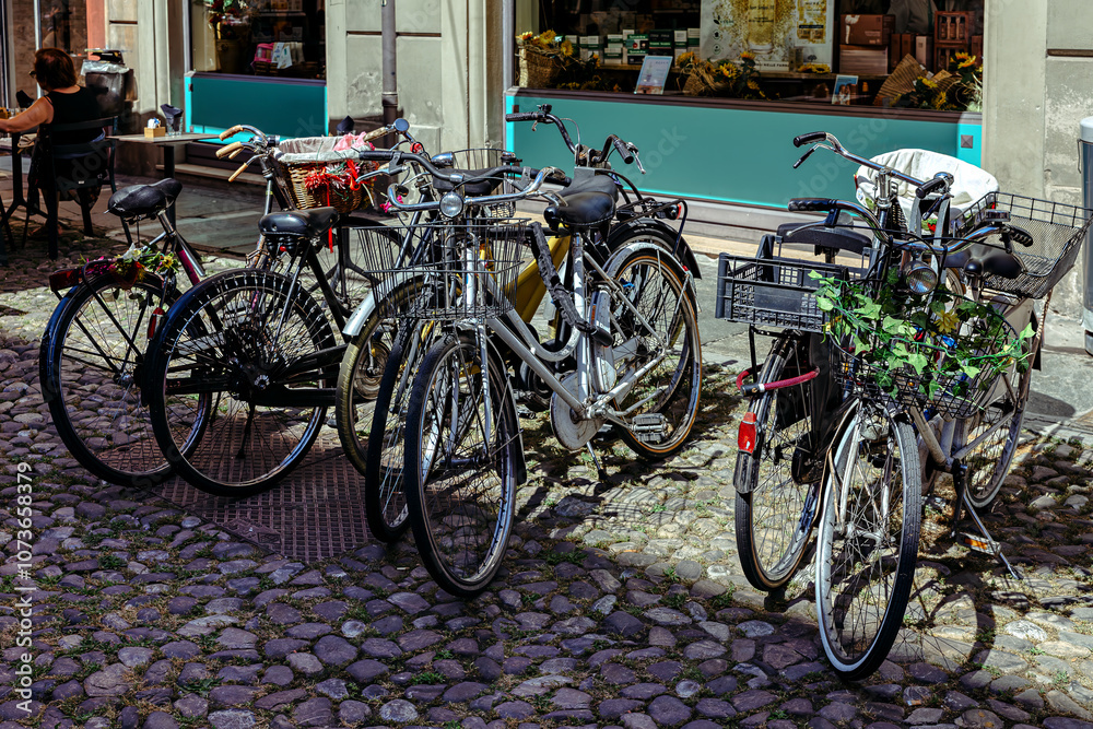 Bicycle parking on a narrow cobblestone street in the medieval city of Modena