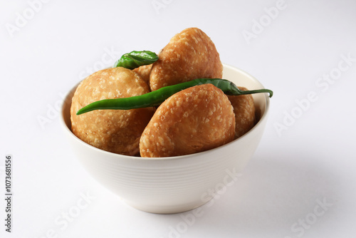 Kachori, green chilly, kachori is a spicy snack from India also called  kachauri and kachodi. Favorite Tea time snacks
served in a ceramic bowl photo