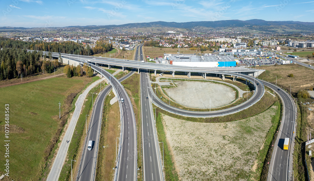 Nowy Trag, Poland. Present end of new Zakopinaka Highway under construction but opened for traffic. Exit rams to old road to Zakopane and Nowy Targ town center. Aerial view. State in October 2024