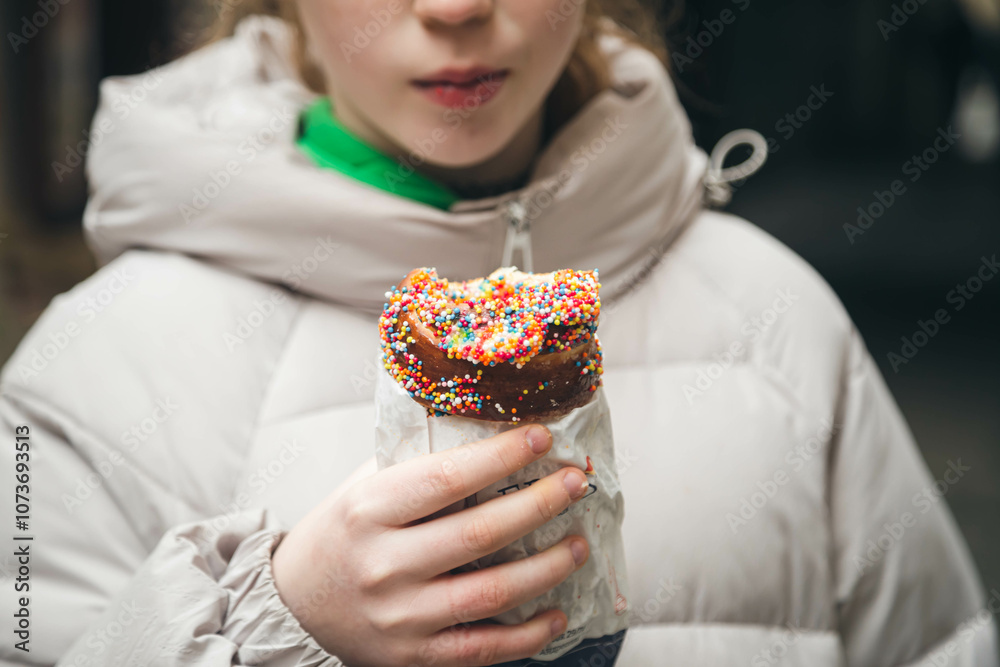 Girl holds in hand Trdlo or Trdelnik, Traditional tasty baked Czech Republic. Girl holds in hand Trdlo or Trdelnik, Traditional tasty baked Czech Republic.