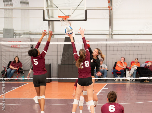 College volleyball player hitting the ball against a double block