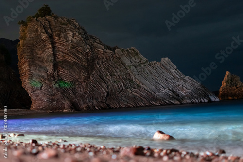 Fracture of huge rocks of layered structure on the coast of Adriatic Sea on dark sky background