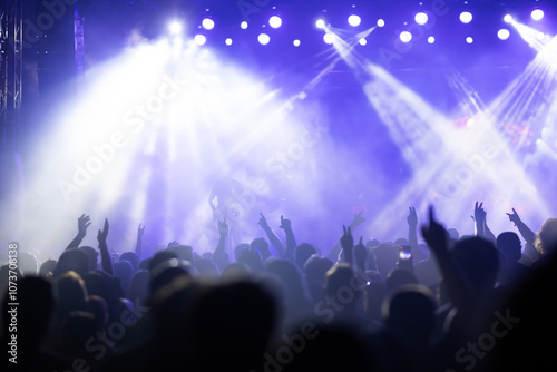 Crowd at concert and colorful stage lights.