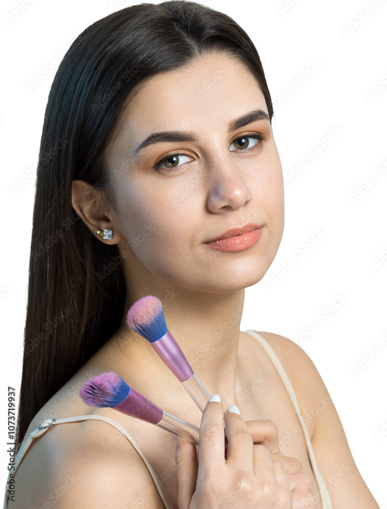 Close-up of a young girl in a light top on a white background making a facial make-up. A pretty woman holds a cosmetic brush near her face and smiles.