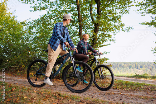 Happy young couple riding bicycles outdoor