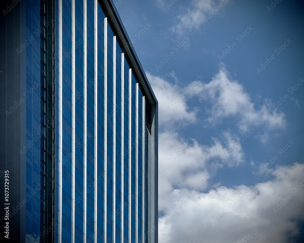 Architecture details of high rise building glass and cladding with blue sky and white cloud Architecture details of high rise building glass and cladding with blue sky and white cloud