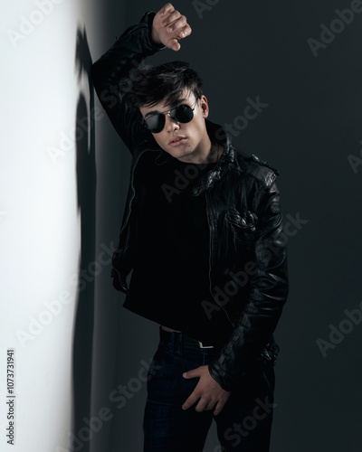 sexy fashion man acting like a heartbreaker in black leather jacket photo